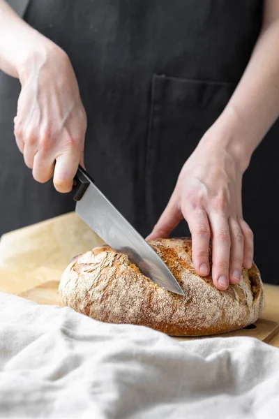 Beyaz kadın fırından taze ekmek çıkarıyor, ev yapımı ekmek pişiriyor.