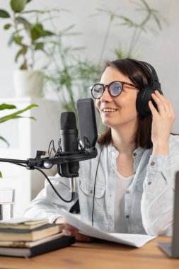 podcast, audio content creation. a beautiful European woman podcaster or radio host records a podcast or content in a recording studio