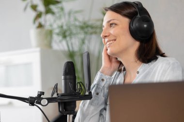 podcast, audio content creation. a beautiful European woman podcaster or radio host records a podcast or content in a recording studio