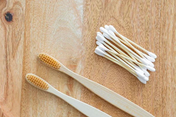 Environmentally friendly bamboo and cotton cotton buds on a pink background, bamboo toothbrushes for adults and children. human personal hygiene products without harming the environment — Stock Photo, Image