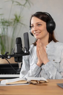 Beyaz kadın podcastları bir kayıt stüdyosunda ya da evinde kaydediyor. Avrupalı bin yıllık kadın ses içeriği yaratır veya metin kaydeder, bir ses kitabı veya radyo programı kaydeder