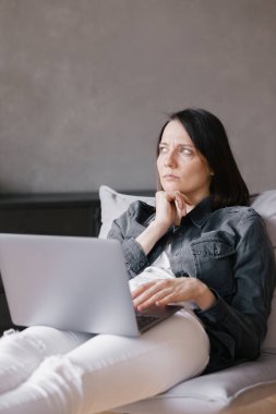Avrupalı kendine güvenen, şık giyinen, dizüstü bilgisayarla çalışan, iş kadını iş yerinde iş arkadaşlarıyla telefonda yazışıp sohbet eden bir kadın.