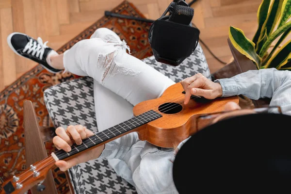 Podcaster crea contenido, mujer feliz músico con grabaciones de guitarra podcast con micrófono y auriculares, mujer caucásica en gafas y sombrero — Foto de Stock