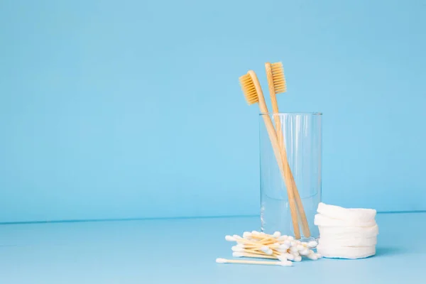 Escovas de dentes de bambu em um fundo azul em um vidro, produtos de cuidados pessoais eco-friendly para pessoas que se preocupam com a raça — Fotografia de Stock