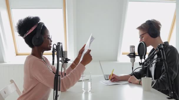 Deux femmes dans un studio d'enregistrement créant du contenu audio, enregistrant un podcast ou une émission de radio — Video