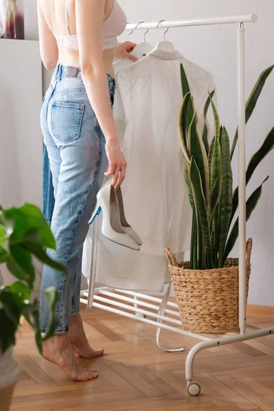 Europäerin zu Hause in ihrem Kleiderschrank wählt Kleidung für eine Party oder eine Geburtstagsfeier, eine Frau in ihrer Unterwäsche wählt Kleidung für Schuhe mit hohen Absätzen — Stockfoto