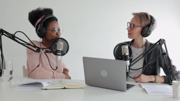 Duas mulheres em um estúdio de gravação criando conteúdo de áudio, gravando um podcast ou programa de rádio — Vídeo de Stock