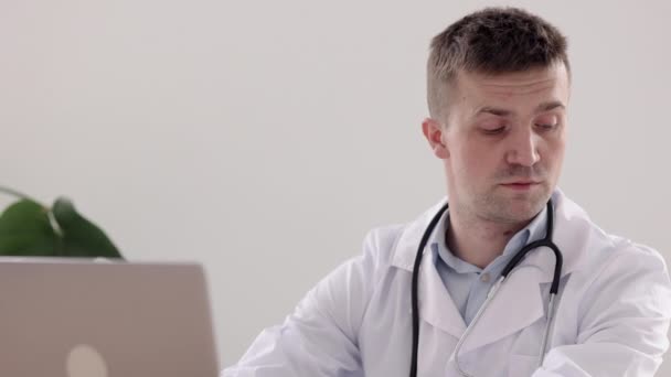 Телемедицина, європейський лікар у білому пальто й окулярах, записує записку в щоденнику і записник. — стокове відео