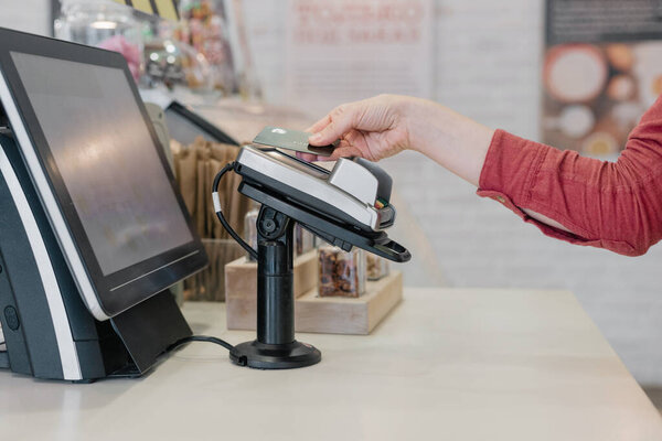 European woman paying with card at restaurant or supermarket