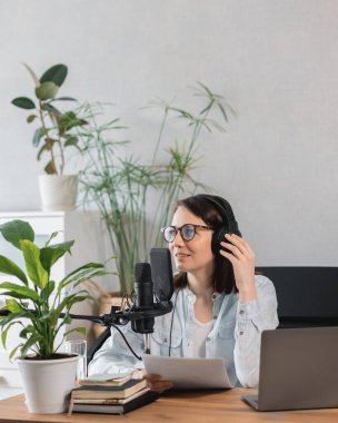 Podcaster içerik yaratır, Avrupalı kadın mikrofon ve kulaklıkla podcast kaydeder, beyaz kadın reklam veya ses kitabı için ses kaydı yapar