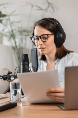 Podcaster içerik yaratır, Avrupalı kadın mikrofon ve kulaklıkla podcast kaydeder, beyaz kadın reklam veya ses kitabı için ses kaydı yapar