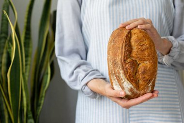 Çıtır çıtır ekmek çok güzel ve iştah açıcıdır. Tahta kesme tahtasının üzerinde lezzetli bir ekmek yatar.