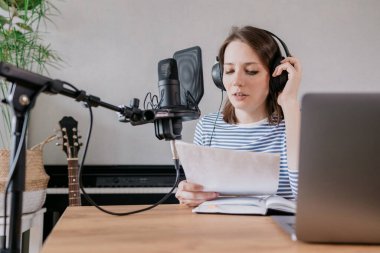 Beyaz kadın podcastları bir kayıt stüdyosunda ya da evinde kaydediyor. Avrupalı bin yıllık kadın ses içeriği yaratır veya metin kaydeder, bir ses kitabı veya radyo programı kaydeder