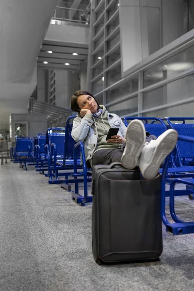 Mujer europea en el aeropuerto esperando abordar sus retrasos de vuelo, vuelo y embarque — Foto de Stock
