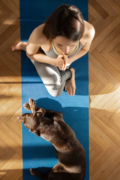 Mulher europeia no tapete de ioga azul meditando em casa — Fotografia de Stock