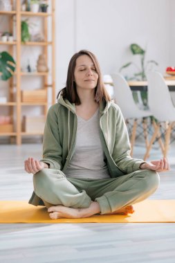 Evde meditasyon ve yoga, yoga yapan güzel ve genç Avrupalı bir kadın.