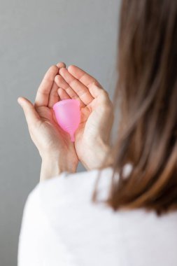 Avrupalı bir kadın elinde silikondan yapılmış pembe bir bardak tutuyor.