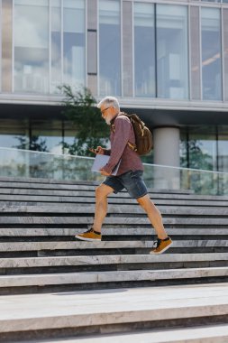 Gömlekli ve dizüstü bilgisayarlı kıdemli bir işadamı büyük bir şirkette kariyer yapıyor.