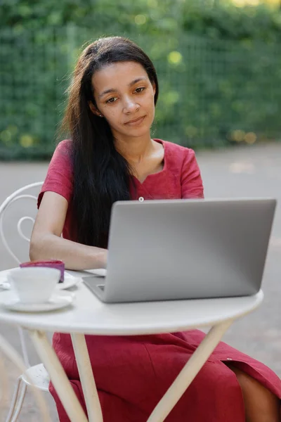 Schöne junge afrikanische Millennial-Frau an einem öffentlichen Ort, die an einem Laptop arbeitet — Stockfoto