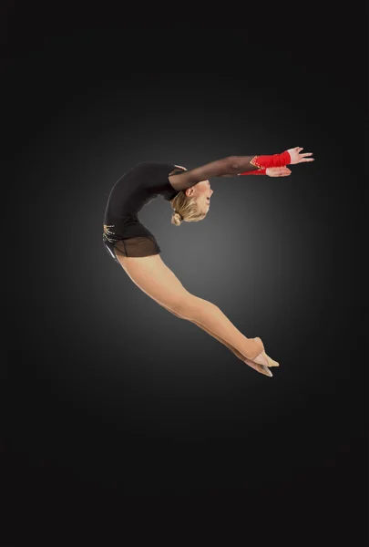 Young flexible ballerina dancing on a bridge in black tights Stock