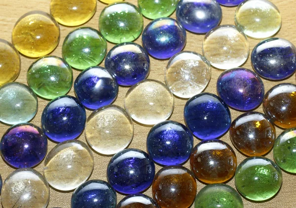 Colored stones on a wooden table, texture — Stock Photo, Image