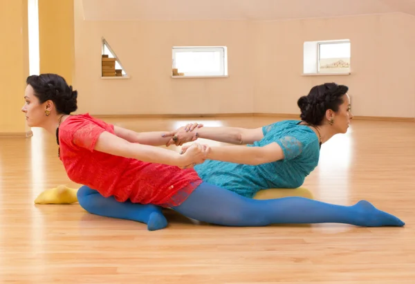 Dos mujeres jóvenes hacen yoga en el interior — Foto de Stock