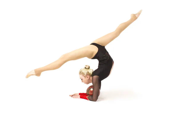 Гнучка молода гімнастка виконує елемент в студії — стокове фото