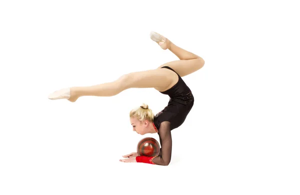 Гнучка молода гімнастка виконує елемент в студії — стокове фото