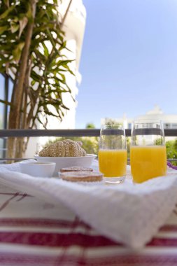 Kahvaltı balkonda servis ediliyor. Portakal suyu, ayçöreği ve kek. Güzel bir günde güzel bir manzara.