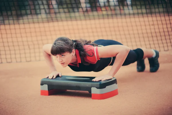 Uma jovem mulher envolvida em fitness ao ar livre — Fotografia de Stock