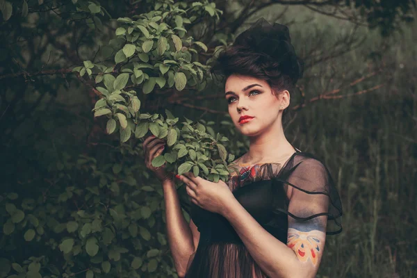 Charmante meisje in een mooie jurk op een achtergrond van de natuur — Stockfoto