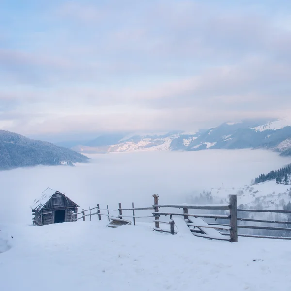Wunderschöne Winterlandschaft mit schneebedecktem Haus und Nebel in den Karpaten, Ukraine — Stockfoto