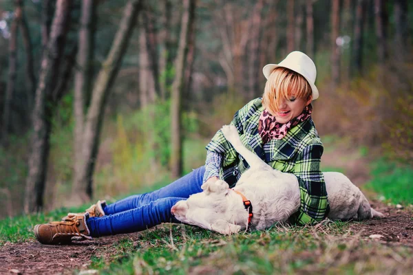 Jovem com um cão na floresta — Fotografia de Stock