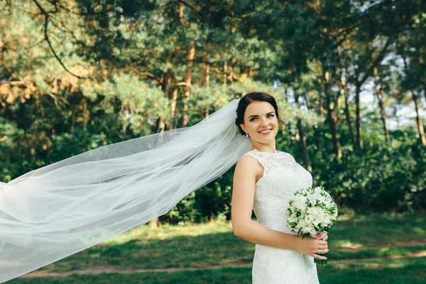 Young and beautiful bride in a long fantasy dress standing — Stock Photo, Image