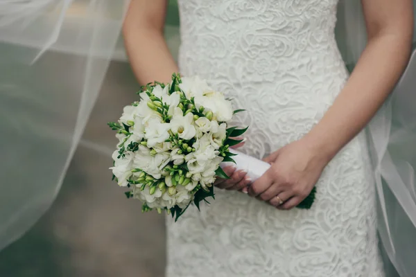 Boeket van witte bloemen in handen van de bruid de bruiloft — Stockfoto