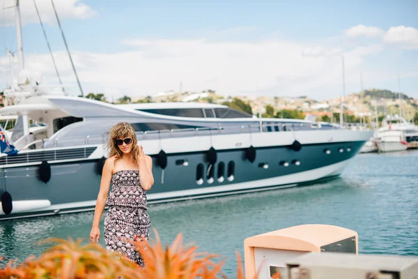 A young pretty girl walking at a port near the moored yachts — Stock Photo, Image