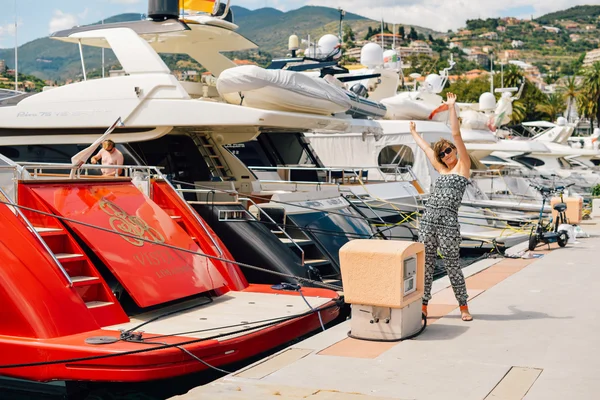 A young pretty girl walking at a port near the moored yachts — Stock Photo, Image