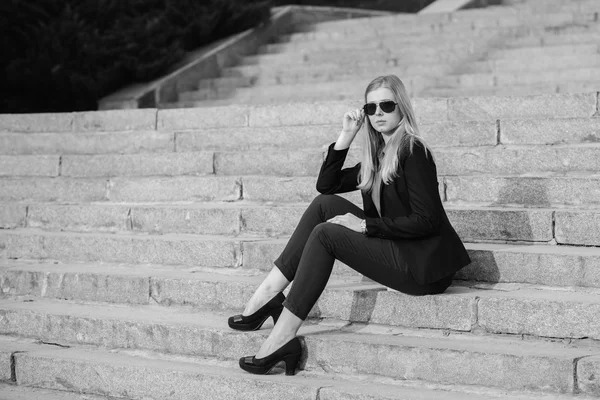 Beautiful pretty girl in sunglasses sitting on stairs — Stock Photo, Image