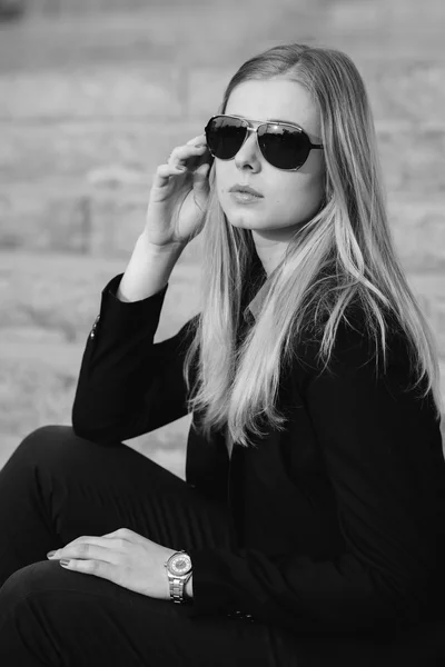 Красива красива дівчина в сонцезахисних окулярах сидить на сходах — стокове фото