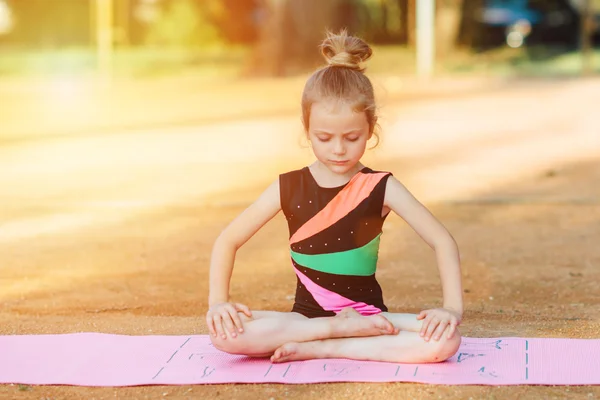 Girl performs gymnastic exercise in the fresh air — Stock Photo, Image