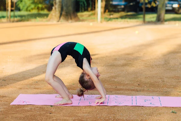 Fille effectue un exercice de gymnastique dans l'air frais — Photo