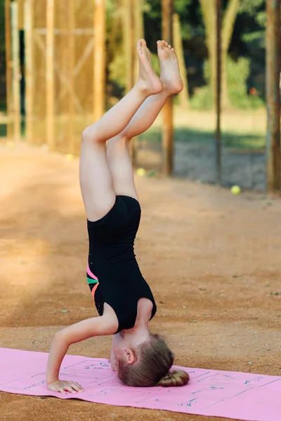 Kız jimnastik egzersiz temiz havada gerçekleştirir. — Stok fotoğraf
