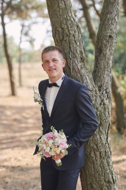 Gülümseyen ve gelin için bekleyen düğün smokin, yakışıklı damat. 