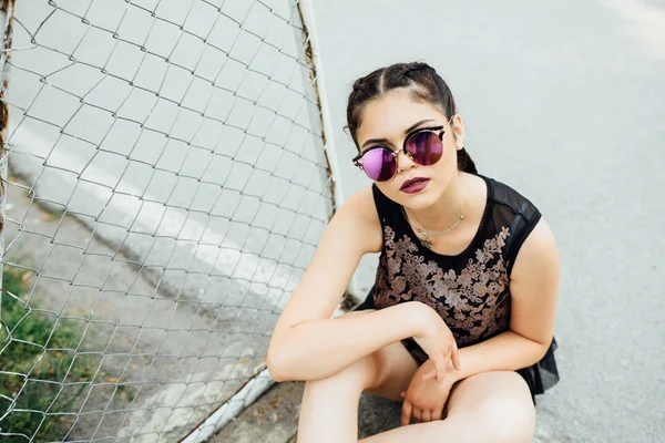 Uma jovem menina bonita caminha em um campo de futebol . — Fotografia de Stock