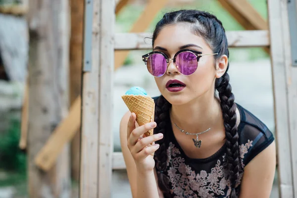 Une jeune jolie fille assise échelle et goûter la crème glacée — Photo