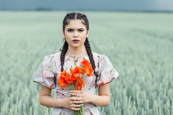 Une jeune jolie fille qui court sur le terrain avec du blé vert — Photo