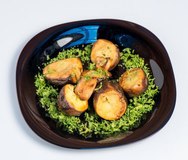 Beyaz arka planda siyah plaka üzerinde kavrulmuş patates