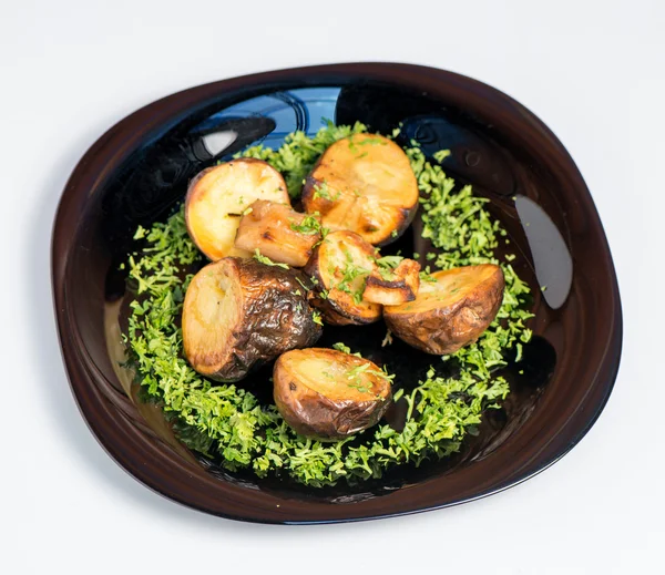 Roasted potato on black plate on white background — Stock Photo, Image