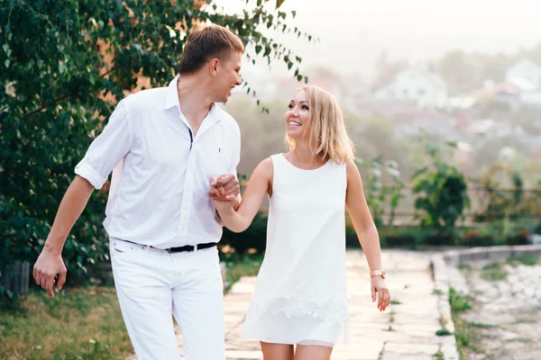 Lindos jóvenes amantes paseando por la calle. Pareja en el amor mira — Foto de Stock