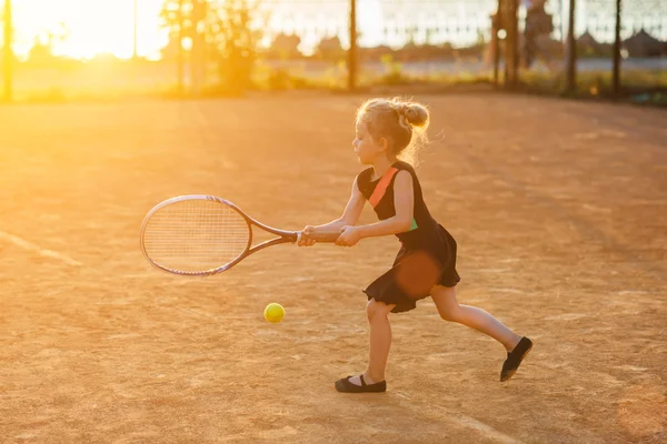 Kleines süßes Mädchen spielt Tennis — Stockfoto